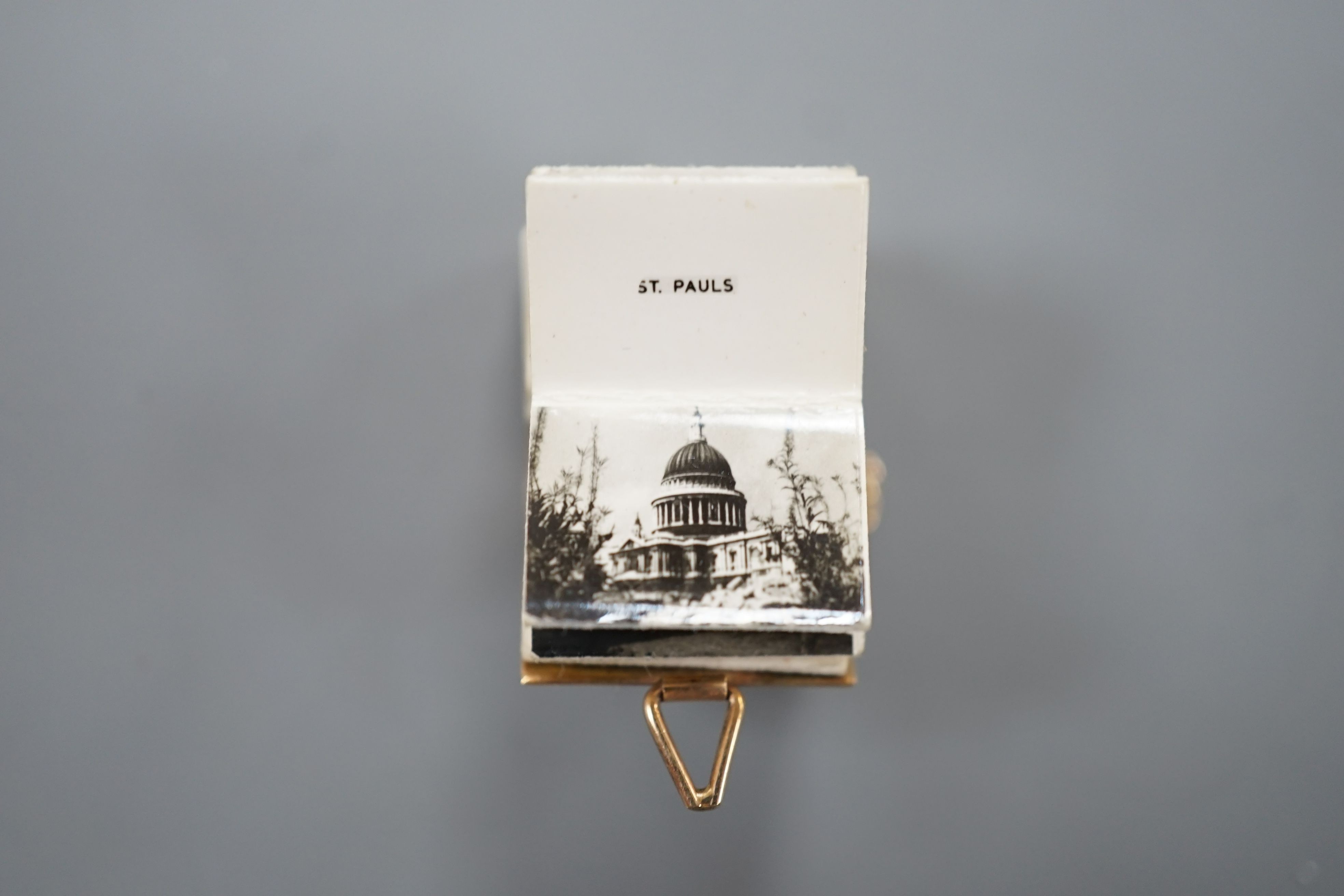 An enamelled 9ct gold photograph album charms with views and crest of London, 1.5cm gross 3.1 grams